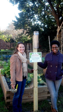 two women checking a rain gauge